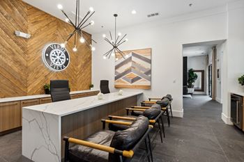 a lobby with a counter and chairs and a clock on the wall